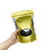 Gold stand up pouch held by hand